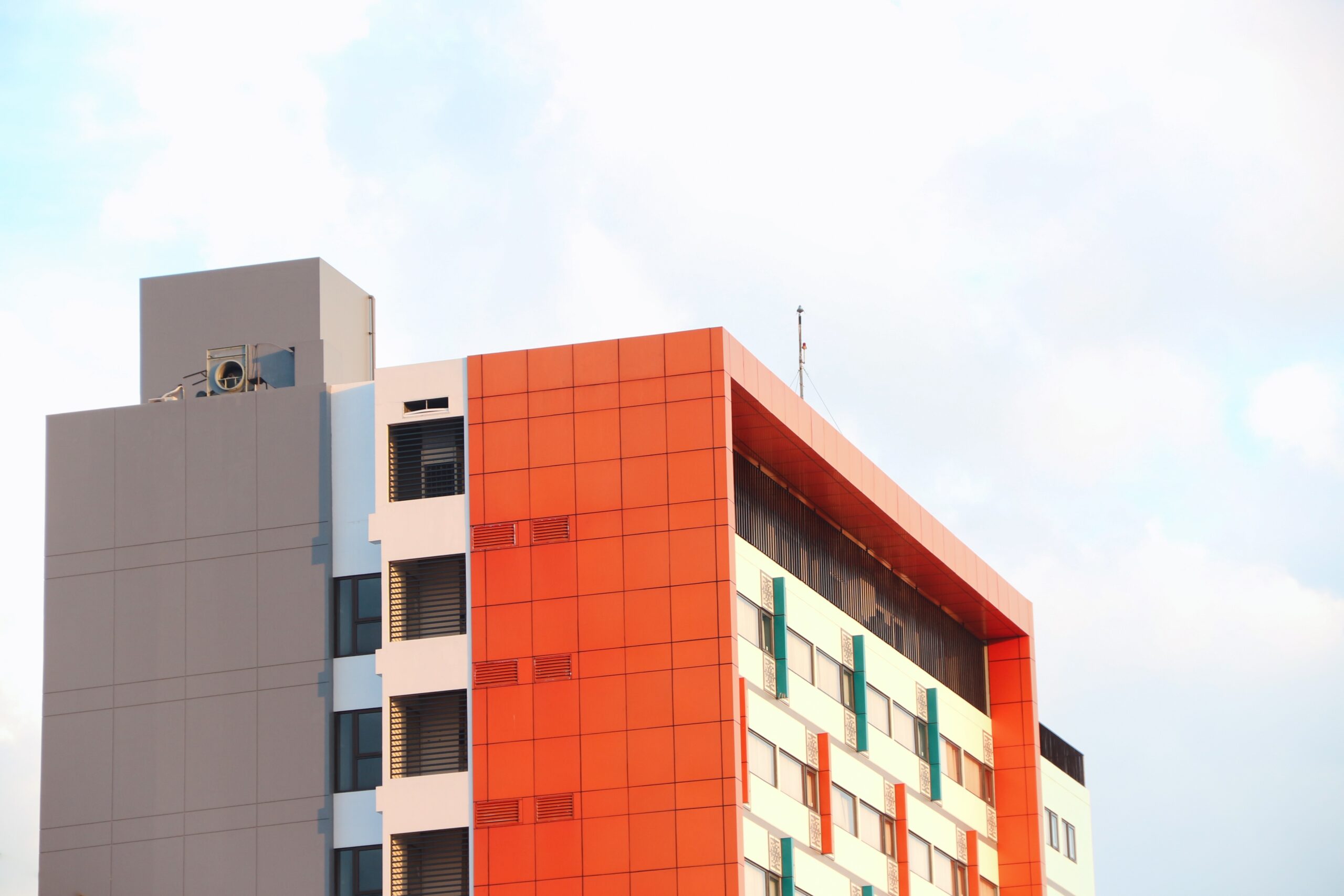 Fachada de edificio con panel de aluminio compuesto en acabado naranja y blanco